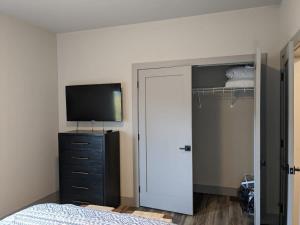 a bedroom with a bed and a tv and a closet at Modern Condo 210 Just Blocks from Lake Michigan in Traverse City