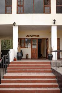 a building with steps leading up to a door at Hostal La Vidala in Tafí del Valle