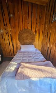 Bett in einem Zimmer mit einer Holzwand in der Unterkunft Cabaña en Valdivia in Valdivia