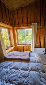 ein Schlafzimmer mit einem großen Bett in einem Zimmer mit einem Fenster in der Unterkunft Cabaña en Valdivia in Valdivia