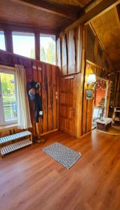 ein Wohnzimmer mit Holzwänden und Holzboden in der Unterkunft Cabaña en Valdivia in Valdivia