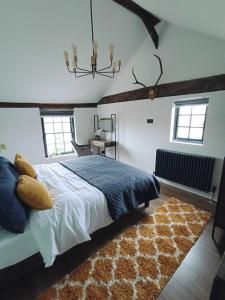 a bedroom with a large bed and a rug at Stansted Airport Cottage in Bishops Stortford