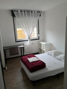 Un dormitorio con una cama con ventana y un escritorio. en 60m2 à 300m de la plage - 4 pers - linge compris - Wifi gratuit, en Berck-sur-Mer
