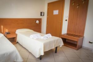una camera d'albergo con due letti e uno specchio di Hotel Jolly a Modugno