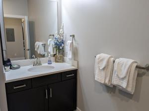 a bathroom with a sink and a mirror and towels at Trendy Downtown Condo-Walk to it ALL Capri 315 in Traverse City