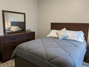 a bedroom with a bed with a mirror and a dresser at Trendy Downtown Condo-Walk to it ALL Capri 315 in Traverse City