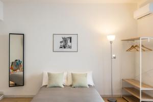 una camera da letto con pareti bianche e un letto con cuscini di Corte Belvedere a Napoli