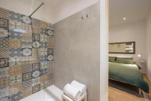 una piccola camera da letto con un letto e uno specchio di Corte Belvedere a Napoli Altre 38 foto