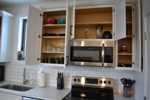a kitchen with white cabinets and a microwave at Downtown Traverse City Capri Condo 316 in Traverse City