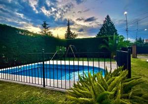 una valla alrededor de una piscina en un patio en Casa por los caminos del vino en Maipú