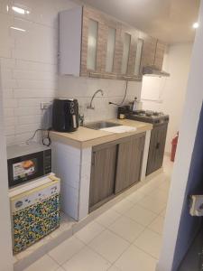 a small kitchen with a sink and a microwave at Apartamento cerca centro bogota in Bogotá