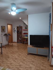 uma sala de estar com uma televisão de ecrã plano e uma ventoinha de tecto em Casa Ferrer Barcelona em L'Hospitalet de Llobregat
