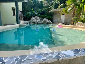 a swimming pool with a water slide in it at Casa Boutique Hokhmah in Puerto Morelos