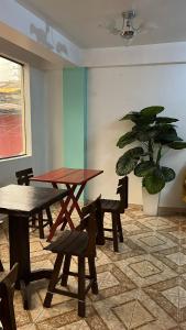 Habitación con mesa, sillas y maceta. en Waylla Hostel, en Huaraz