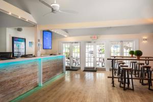 un bar junto a la piscina en una habitación con mesas y sillas en Nyah - Adult Exclusive, en Key West