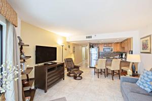 a living room with a couch and a tv and a kitchen at Sunglow Resort Condo Unit #806 in Daytona Beach Shores