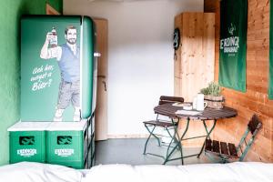 Ein Tisch und eine Tür mit einem Poster eines Mannes, der ein Handy hält in der Unterkunft heimatbude Loft in Rotenhain
