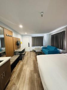 ein Hotelzimmer mit einem Bett, einem Schreibtisch und einem Sofa in der Unterkunft Motel 6-Santa Ana, CA in Santa Ana