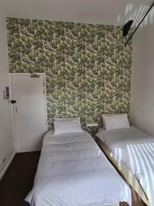 Clipston的住宿－The Bulls Head, Clipston，墙上的房间里设有两张床