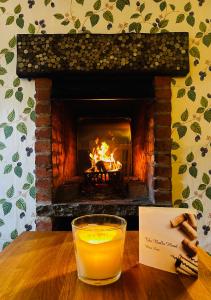 a glass of orange juice on a table with a fireplace at The Bulls Head, Clipston in Clipston