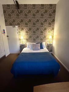 Clipston的住宿－The Bulls Head, Clipston，一间卧室配有一张带蓝色毯子的床