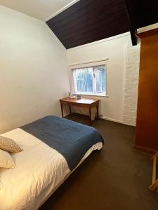 1 dormitorio con cama, escritorio y ventana en The Bulls Head, Clipston en Clipston