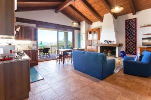 a kitchen and living room with blue chairs and a table at Brassol Casa Vacanze Vista Mare in Alghero