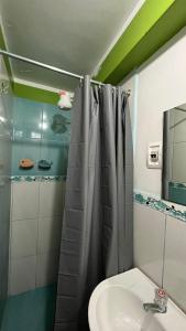 a bathroom with a shower curtain and a sink at Waylla Hostel in Huaraz
