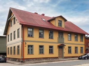 a large wooden house with a red roof at Avar ja hubane stuudiokorter kesklinnas in Viljandi