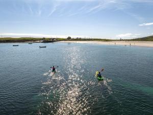 two people are in the water near a beach at No.3 Mill Park a luxury self-catering apartment in Donegal