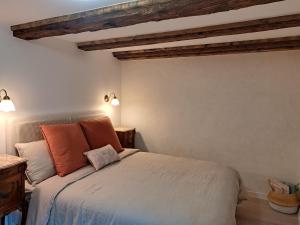 - une chambre avec un lit et des oreillers orange dans l'établissement Grand gîte dans maison alsacienne historique, à Gueberschwihr