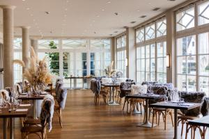 un comedor con mesas, sillas y ventanas en Schloss Neckarbischofsheim en Neckarbischofsheim