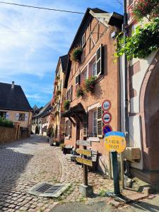una calle en una ciudad con un cartel en un edificio en Grand gîte dans maison alsacienne historique, en Gueberschwihr