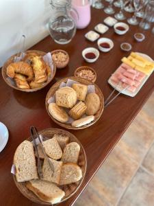 a table topped with baskets of bread and pastries at Hostal La Vidala in Tafí del Valle
