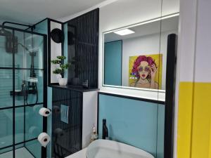 un baño con aseo y una pintura de una mujer en Flawsome stays colourful Whimsical Apartment with Garden close to Ramsgate Harbour great for families, en Ramsgate