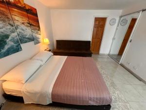 Cama grande en habitación con sofá en Apartamento Nuevo Conquistador, en Cartagena de Indias
