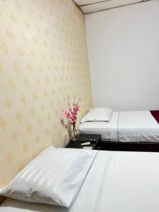 a bedroom with two beds and a vase of flowers at Hotel Boutique Casa Dorada in Neiva