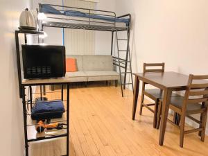 Una habitación con un escritorio y una litera con una mesa. en Shered bathroom 4 SofaBed + loftbed + kitchen, en Nueva York