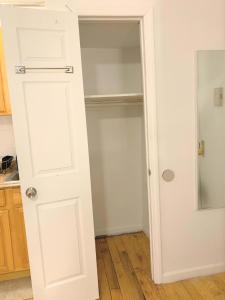 Un armario con una puerta blanca en una cocina. en Shered bathroom 4 SofaBed + loftbed + kitchen, en Nueva York 2 fotos más