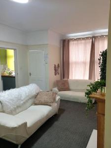 a living room with two white couches and a window at A Cosy Private Space- Free Wifi & Parking in Leeds