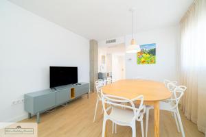 ein Esszimmer mit Tisch und Fernseher in der Unterkunft Brend new beach Apartment 3 bed 2 bath Play Camp in El Campello