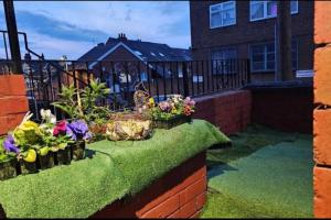 a garden with flowers on a brick wall at A Cosy Private Space- Free Wifi & Parking in Leeds