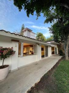 a white house with a porch and a driveway at Oasis en Yautepec, alberca, jacuzzi y naturaleza in Yautepec