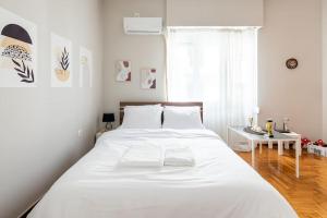 um quarto branco com uma grande cama branca e uma mesa em Prestige apartment in the heart of Athens ( 1 ) em Atenas