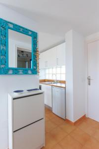 eine Küche mit weißen Schränken und einem Wandspiegel in der Unterkunft Astarita SUN in Costa Calma