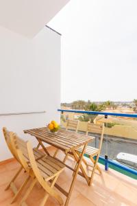 a wooden table and chairs in a room with a balcony at Astarita SUN in Costa Calma