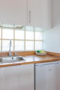 a kitchen with white cabinets and a sink at Astarita SUN in Costa Calma