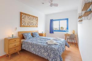 Schlafzimmer mit einem Bett, einem Tisch und einem Fenster in der Unterkunft Astarita SUN in Costa Calma