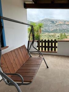 un banco sentado en un balcón con vistas a la montaña en Villetta Oddoene, en Dorgali