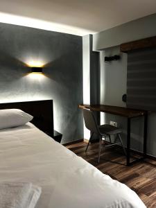 - une chambre avec un lit, un bureau et une chaise dans l'établissement Wooden Suites, à Thessalonique